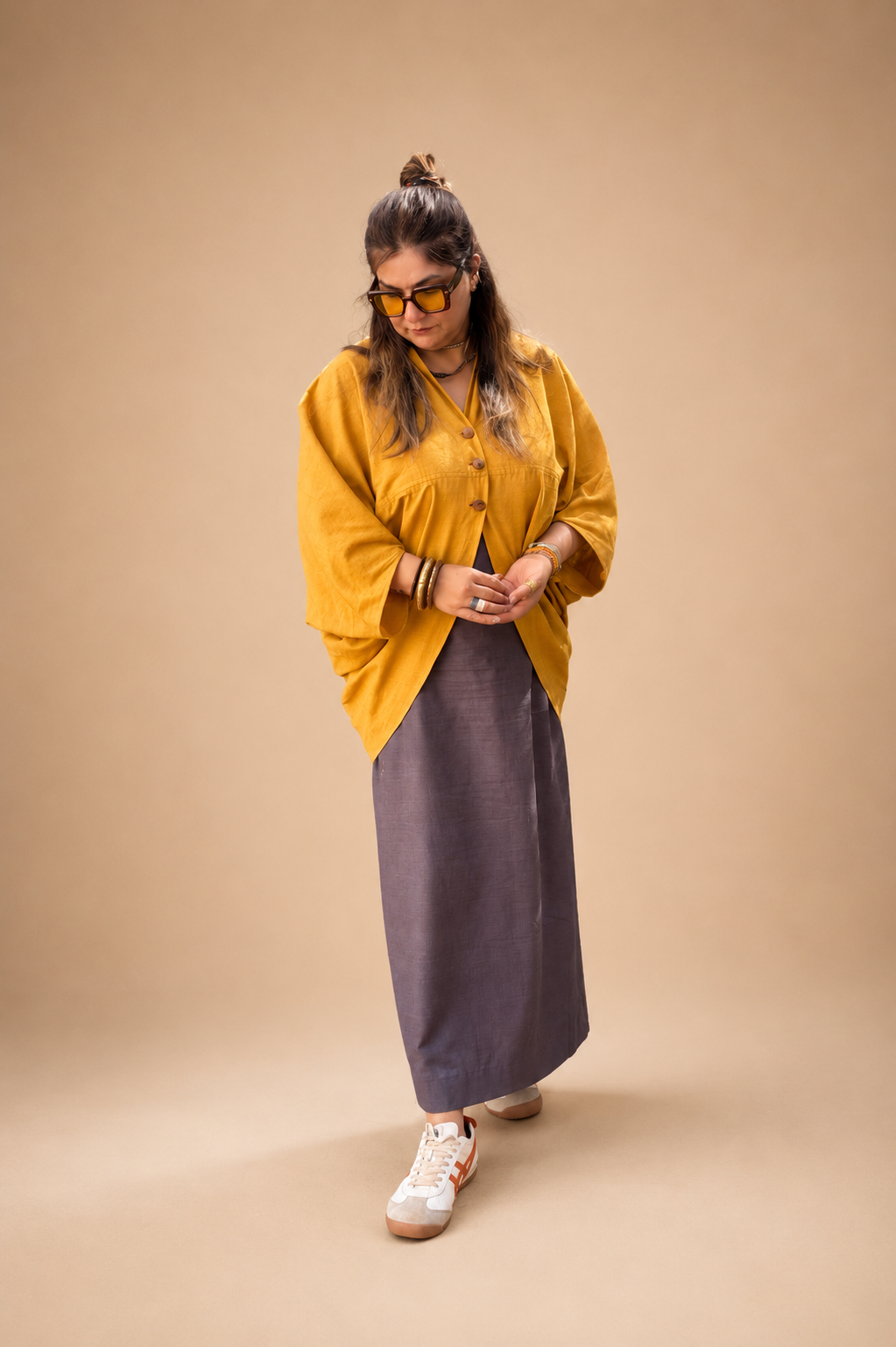Oversized mustard cape paired with a fitted long skirt featuring a long back slit and a contemporary statement silhouette by Bohe by NAM.