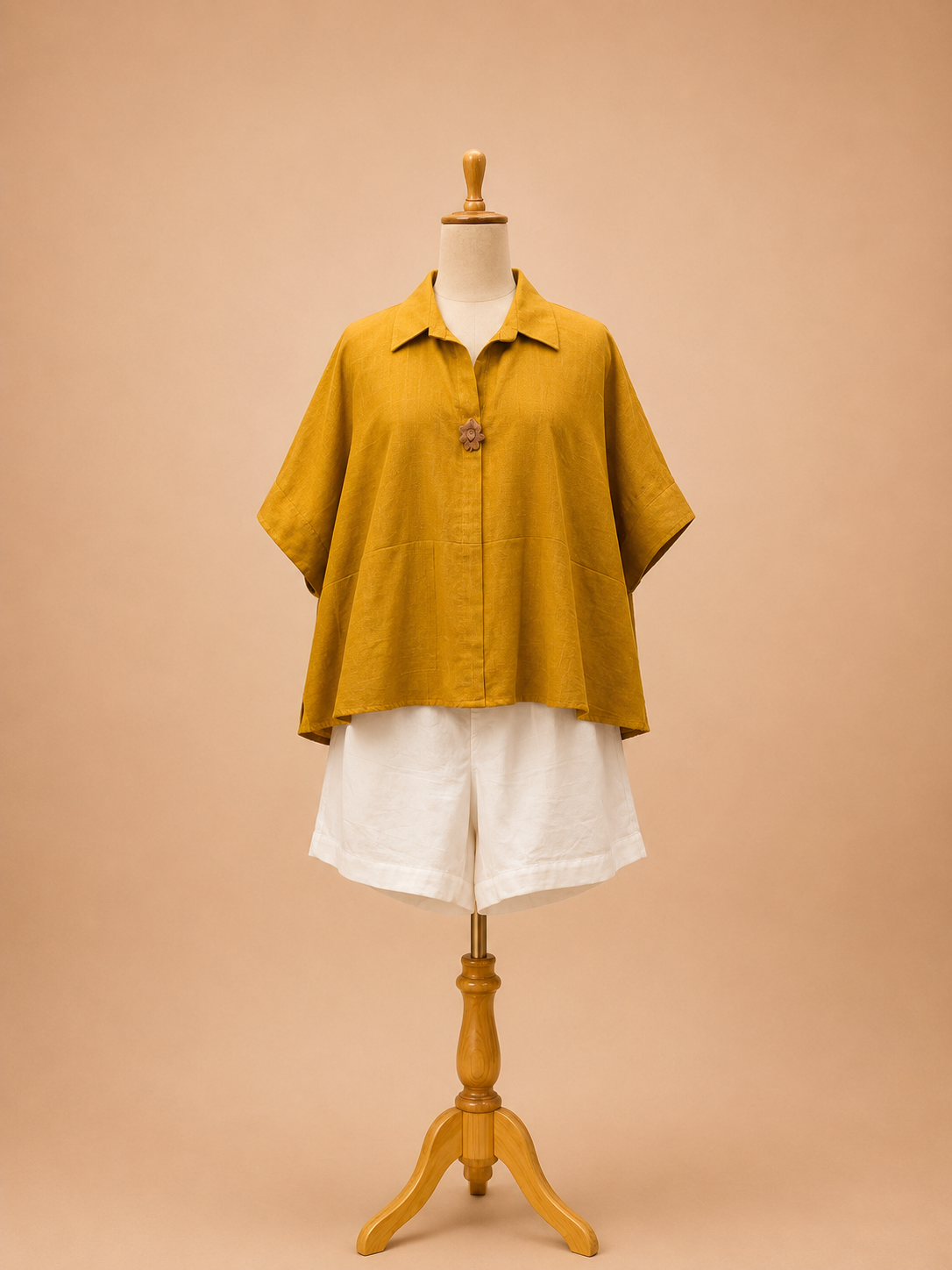 Mustard poncho top paired with pleated shorts in khadi, featuring a relaxed silhouette and contemporary artisanal design by Bohe by NAM.