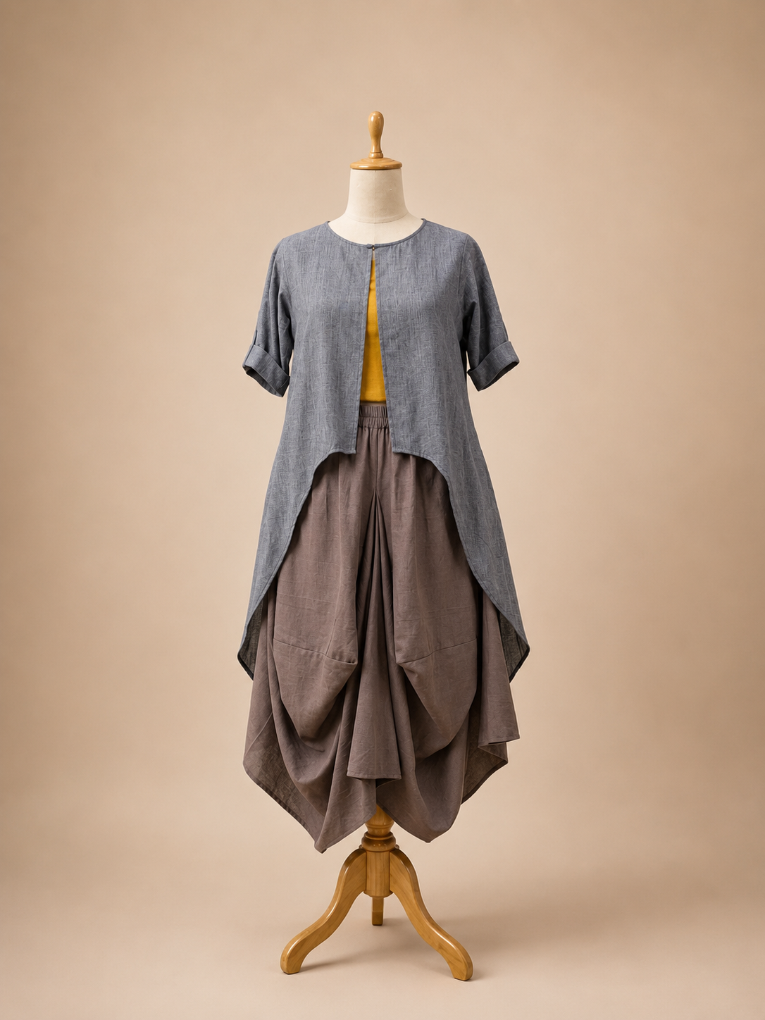 Three-piece khadi ensemble featuring a boho skirt, bustier, and asymmetrical high-low jacket with a handpainted sunflower motif on the back by Bohe by NAM.